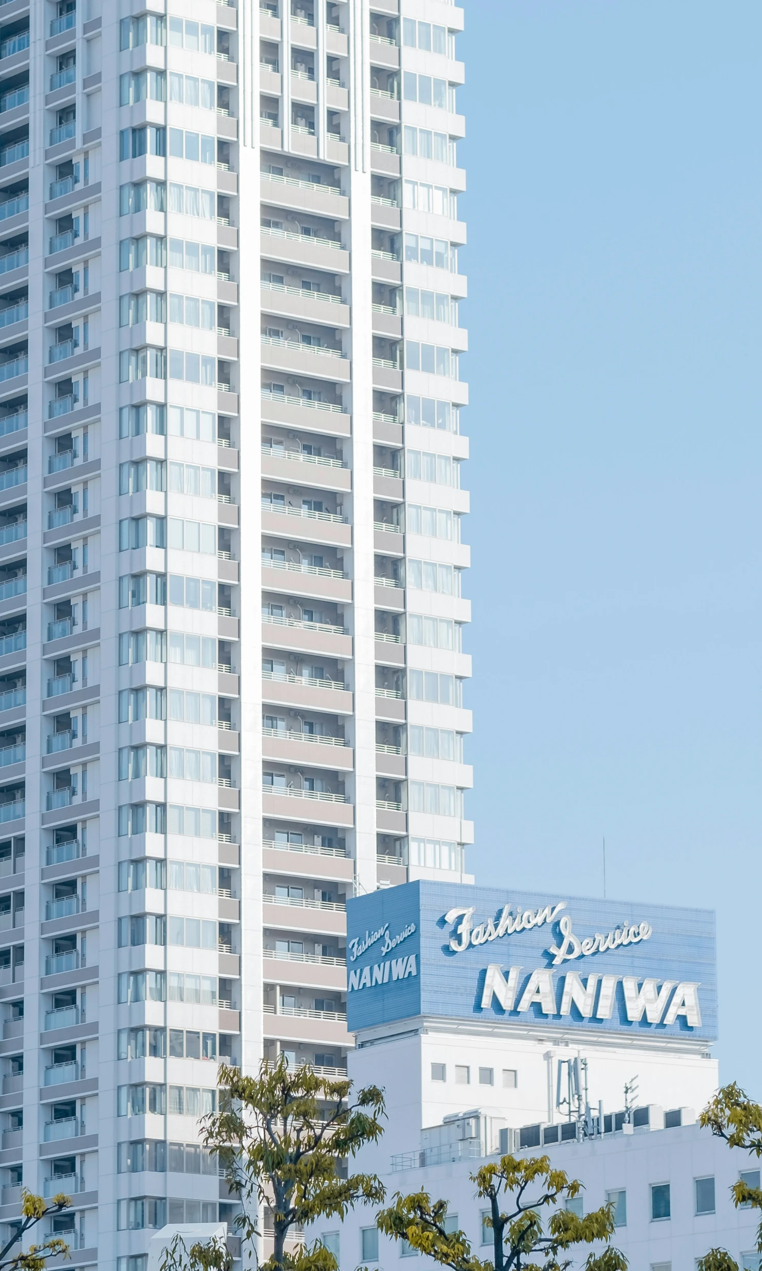 the tall building with a sign in front of it is next to another high rise