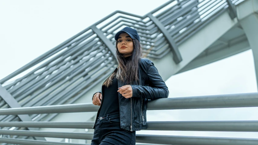 a woman leaning against a fence in front of a building