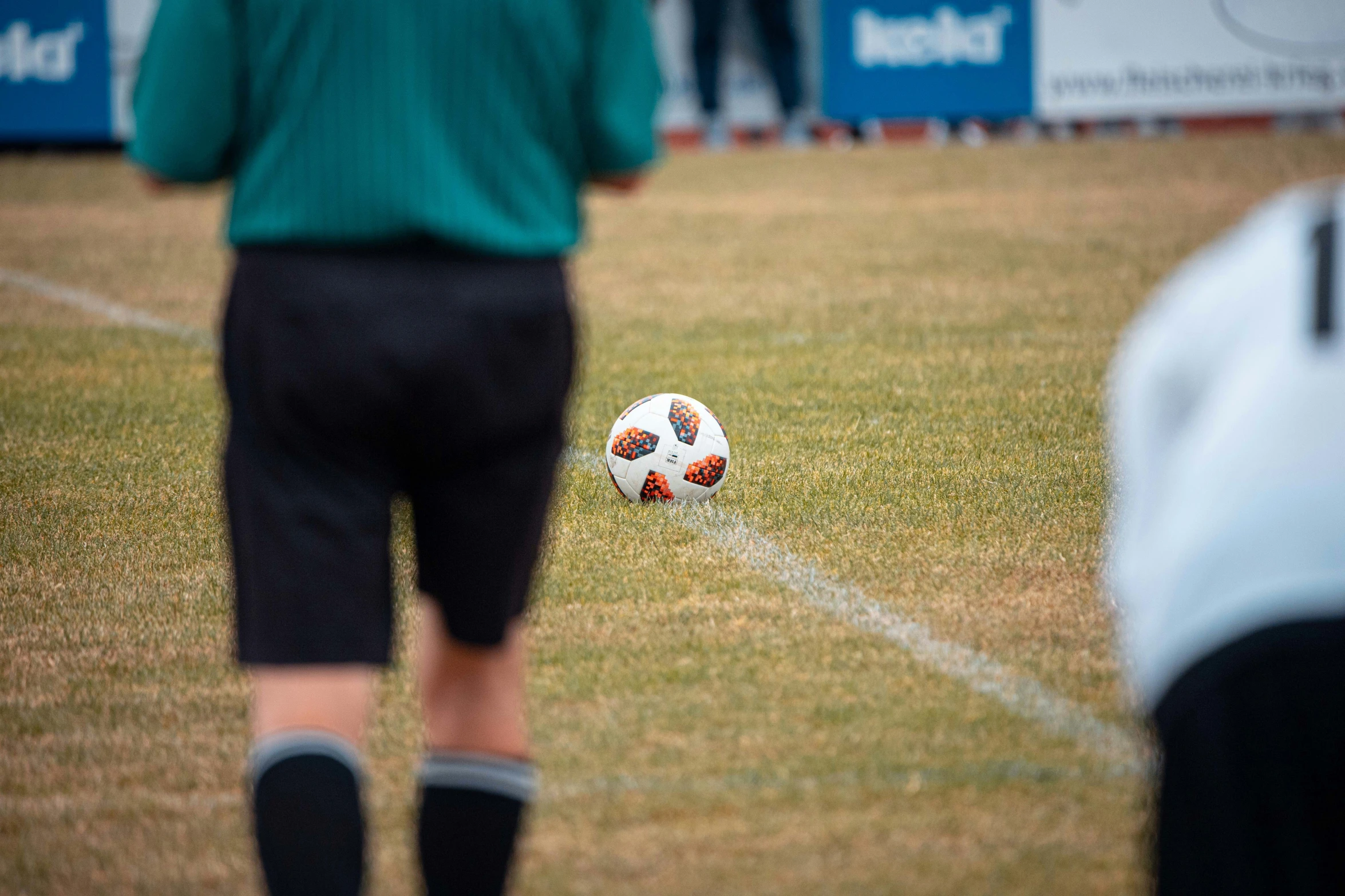 a soccer ball is laying on the ground as people watch