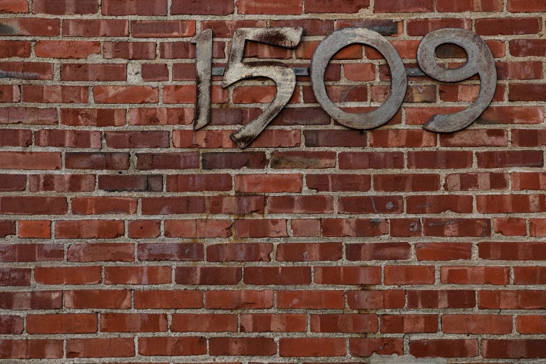 a metal sign reads 997 on a brick wall