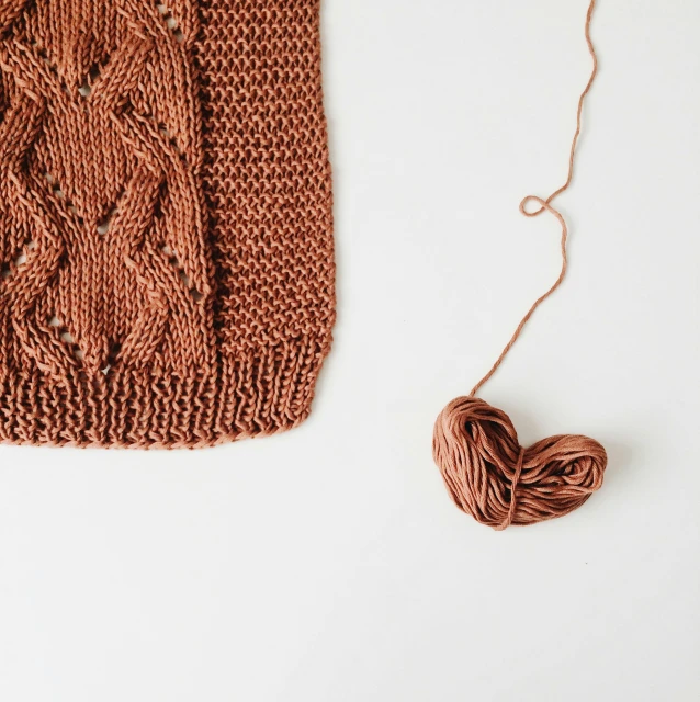 an antique sweater being knitted next to an apple ornament