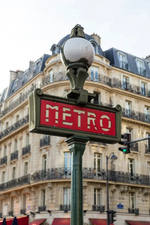 a red metro sign that reads metro next to a building