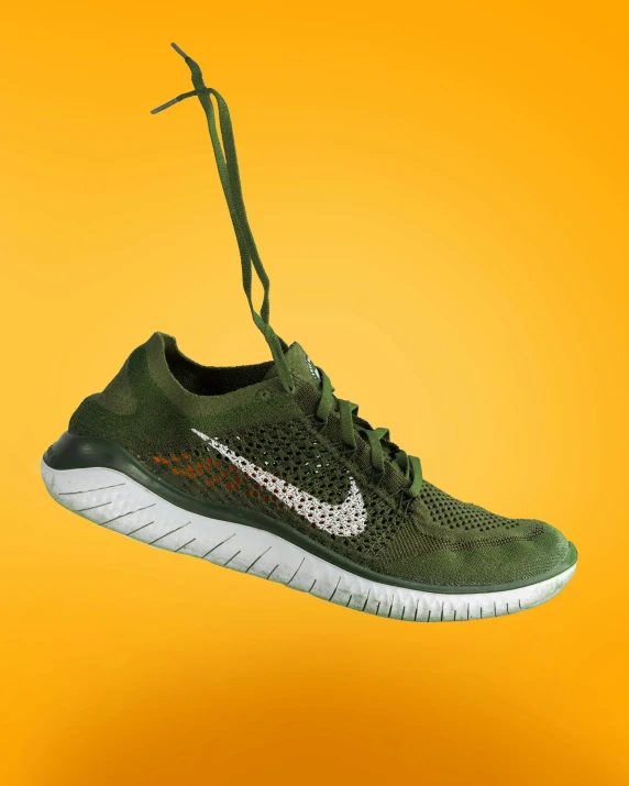 a green nike shoe with laces hanging off of it