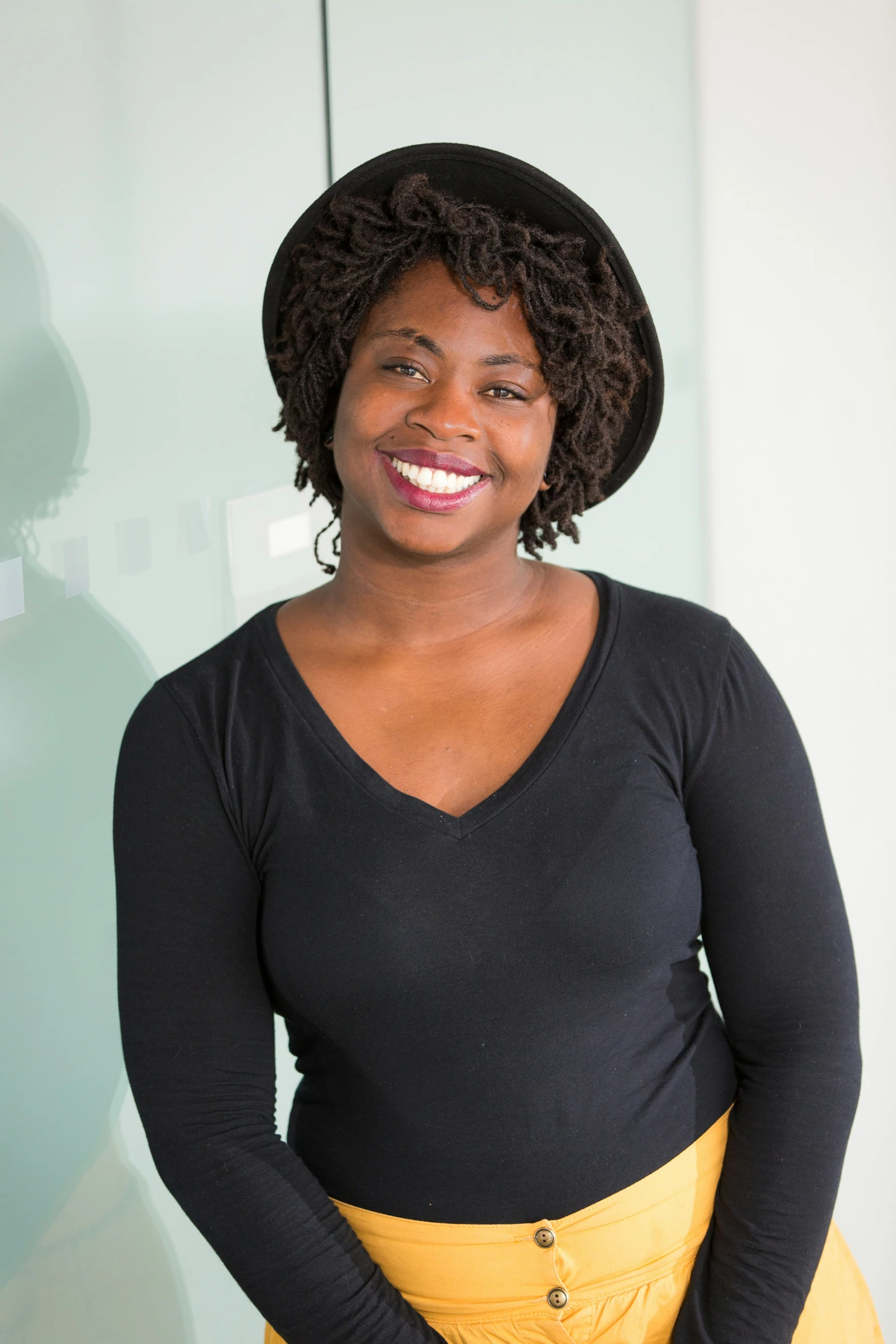 a woman smiling in her yellow skirt and black top