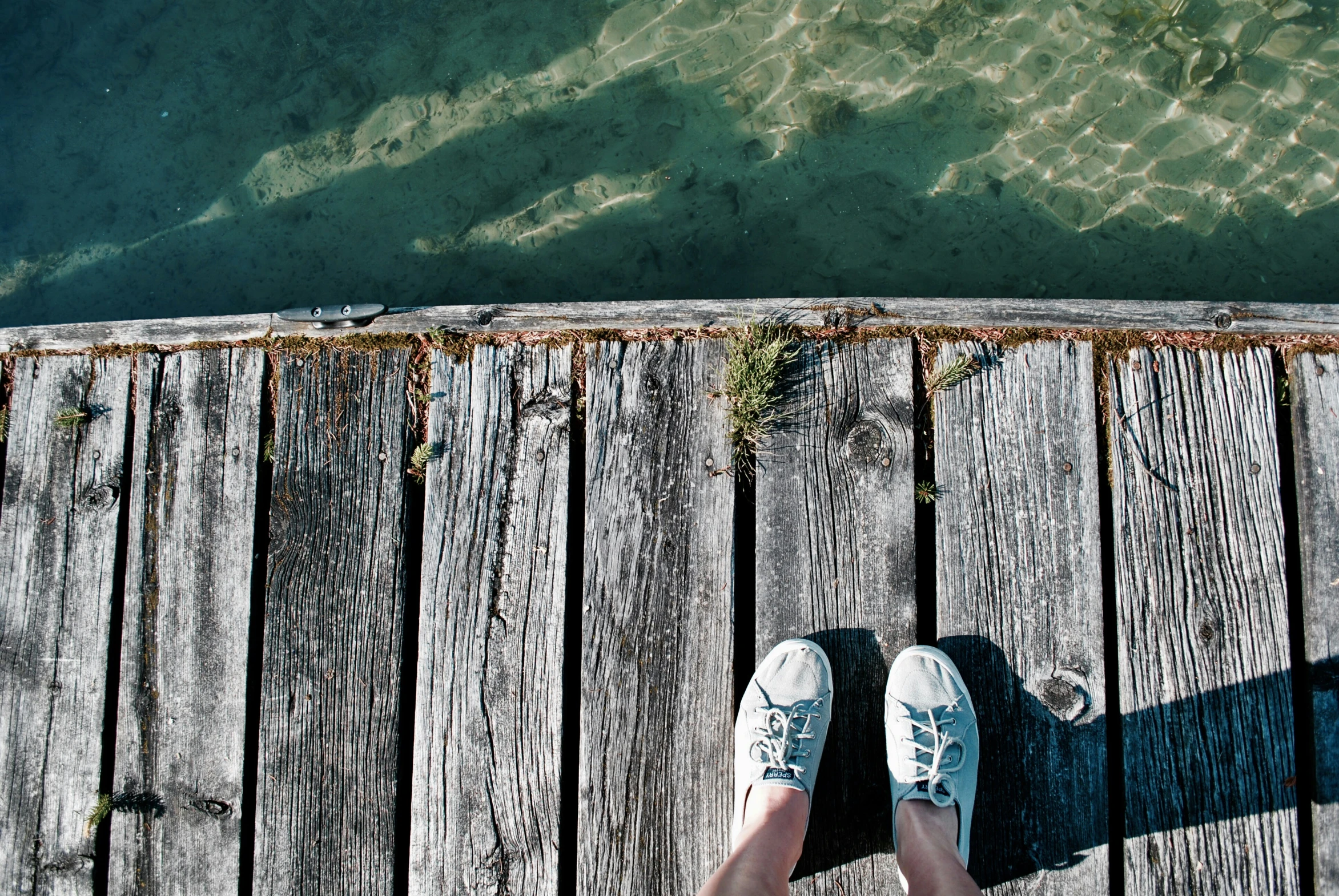 someone standing at a pier looking out at the water