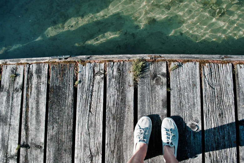 someone standing at a pier looking out at the water