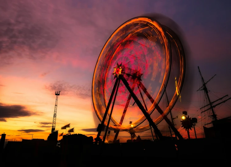 an amut park rides wheel at dusk with a dark sky