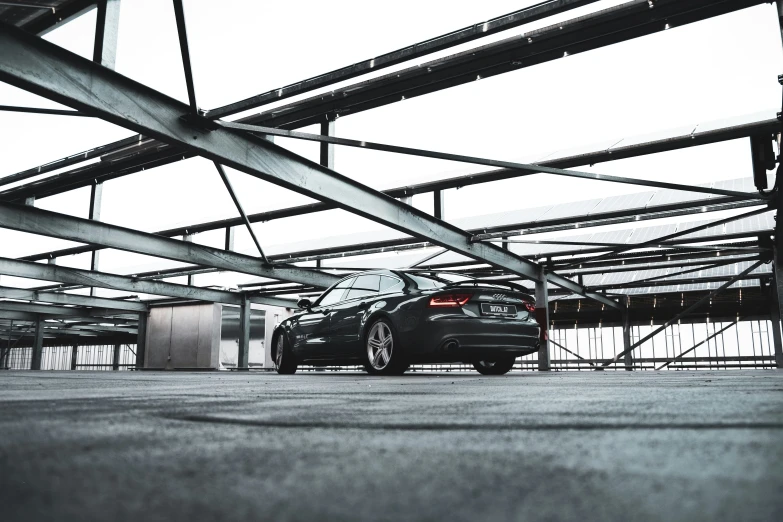 car parked under metal structures in large industrial area