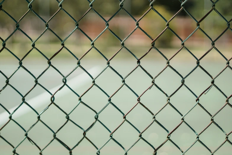 an tennis court has a wire fence to it