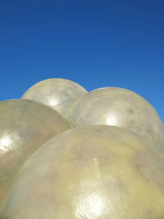 a large group of large round objects sitting in front of a clear blue sky