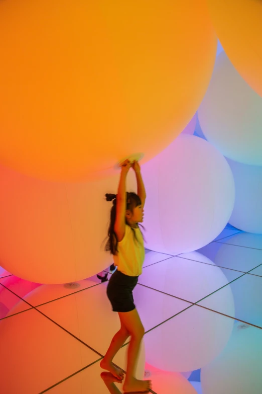 a young woman balancing large balloons over her head