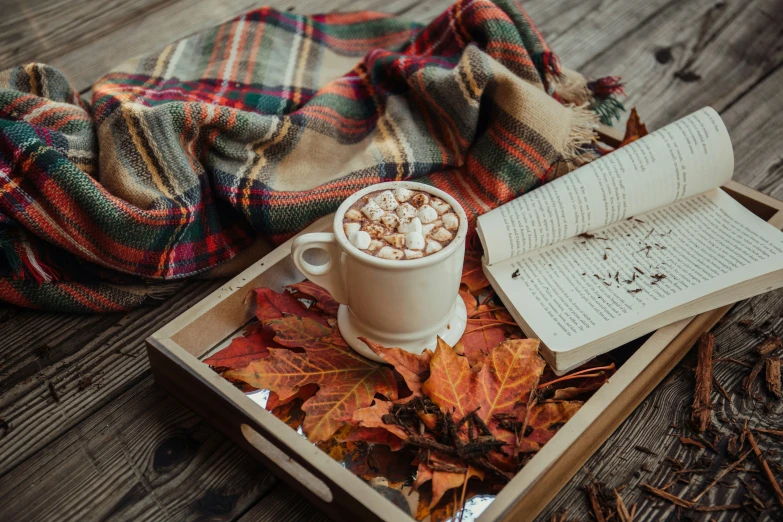 an open book and coffee on top of a table