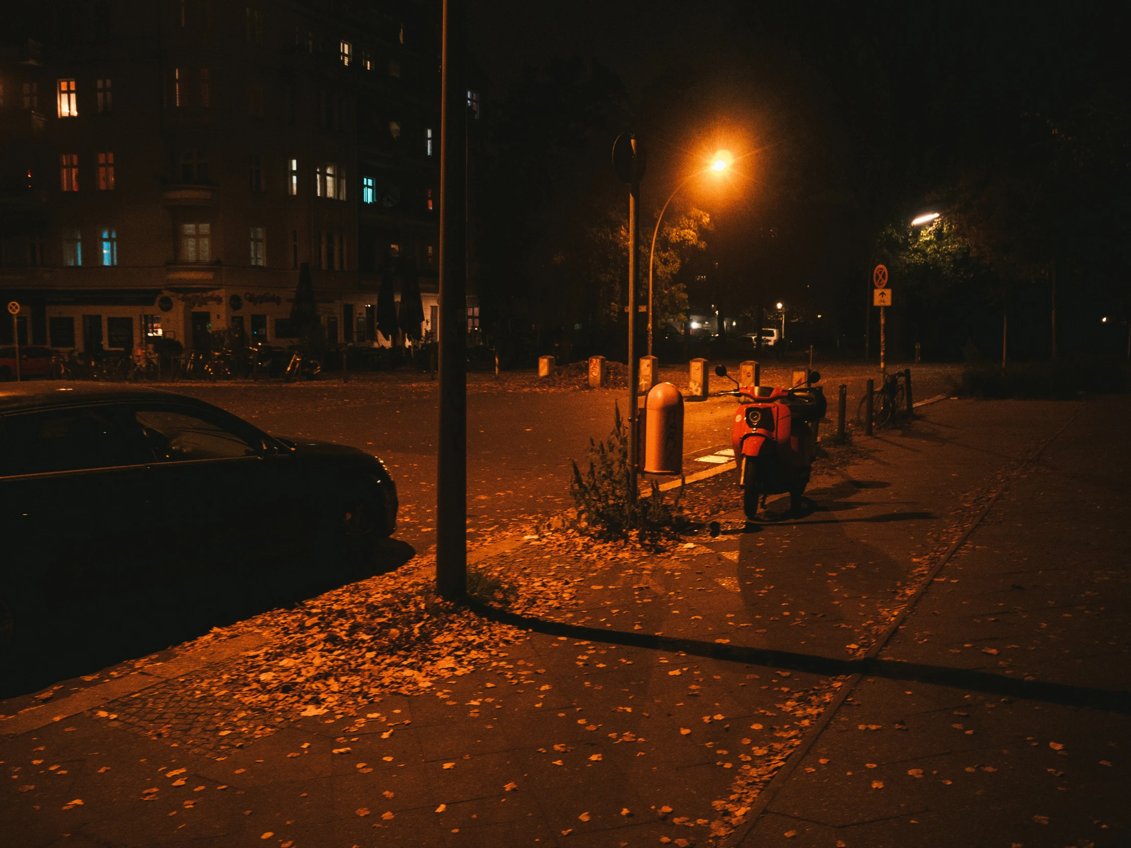 a city street at night with people and cars in the foreground