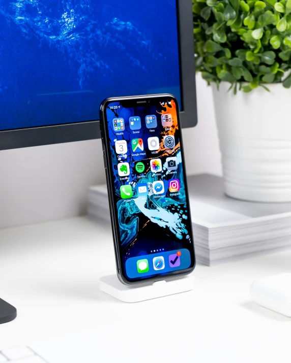 the dock for an iphone, computer and mouse are on the desk