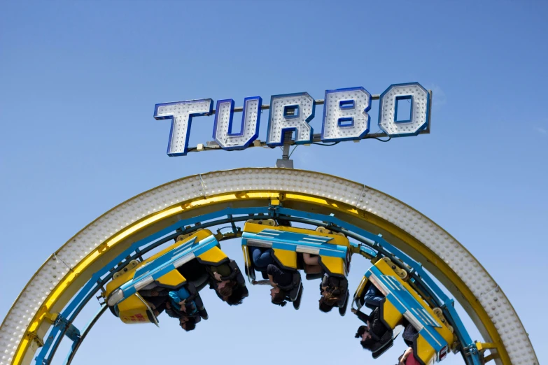 an amut ride is pictured in the distance under a sign for turboo