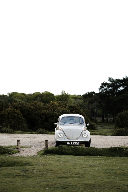 a white car is parked near a gravel road