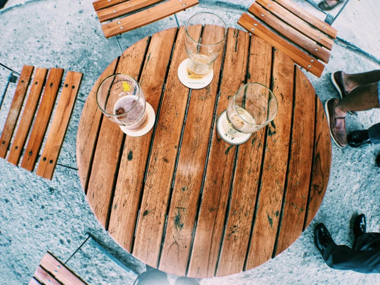 two people are sitting at the round wooden table