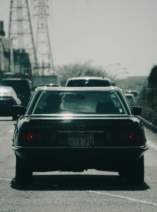 a black car is driving past an ferris wheel