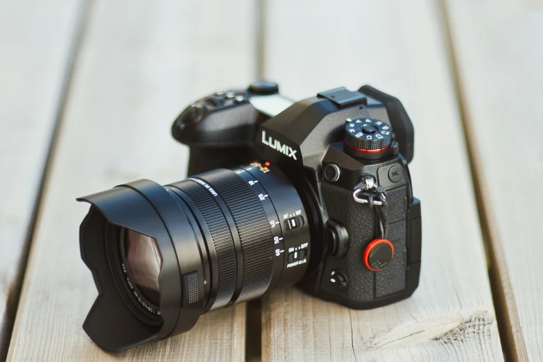 a black camera with the lens on a wooden surface