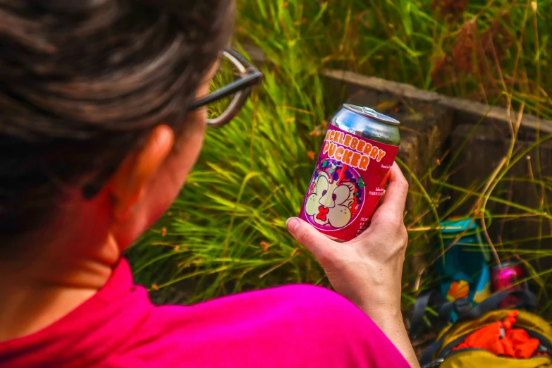 woman in pink shirt holding a soda can