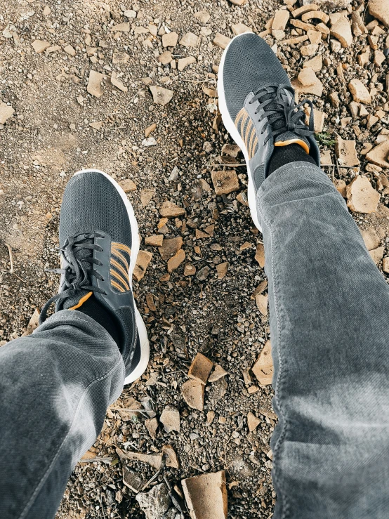 a person's feet in the middle of some gravel