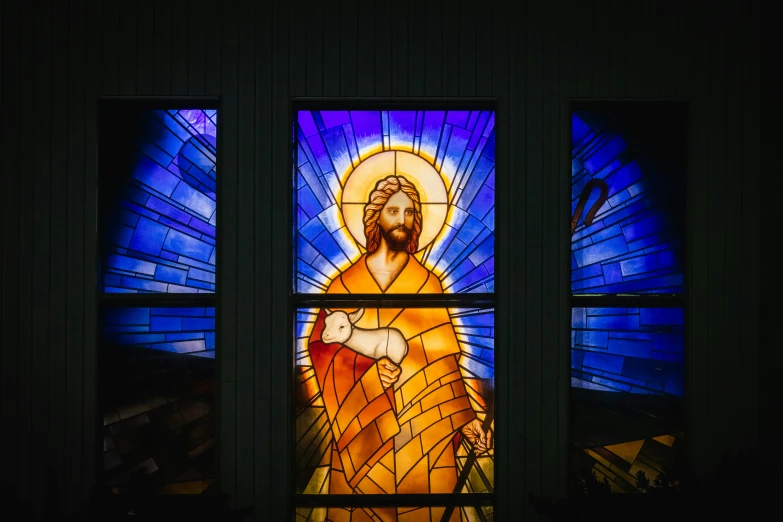 a stained glass window depicting jesus and mary in a darkened room