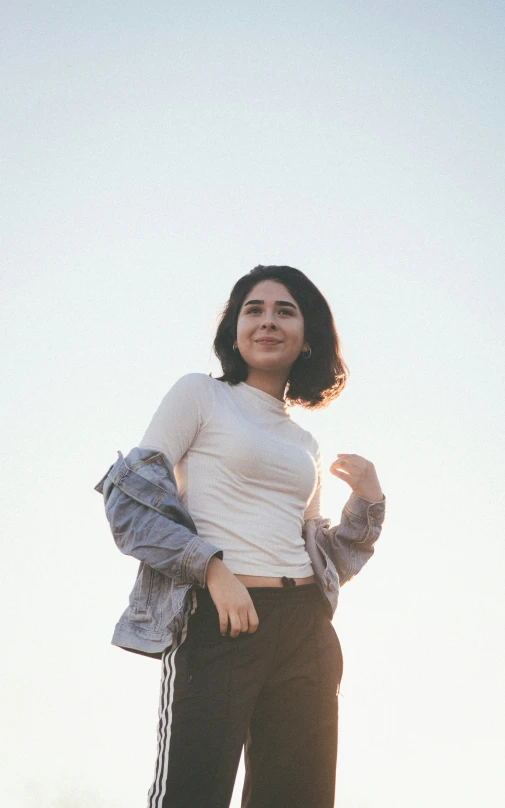 a woman poses in front of a blue sky