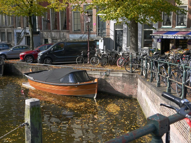 a boat floating next to bicycles parked near buildings