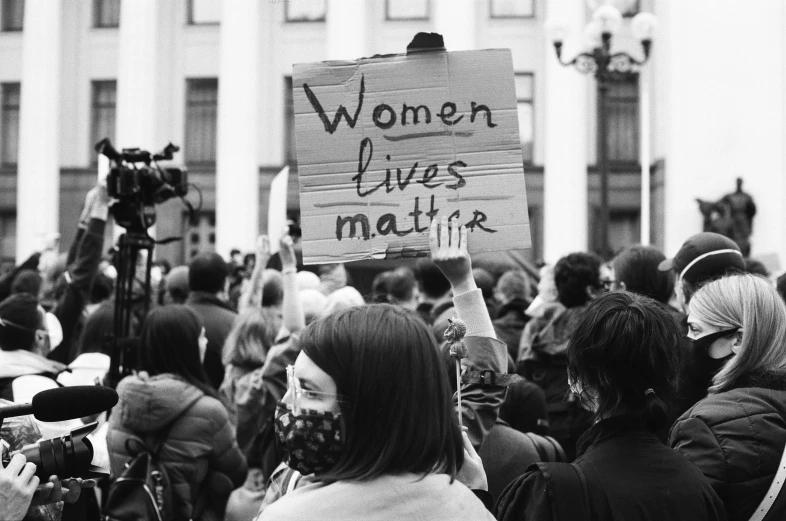 a woman with a sign that says women lives matter
