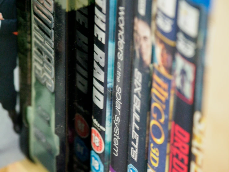 several people standing next to each other while looking at a large shelf with dvds