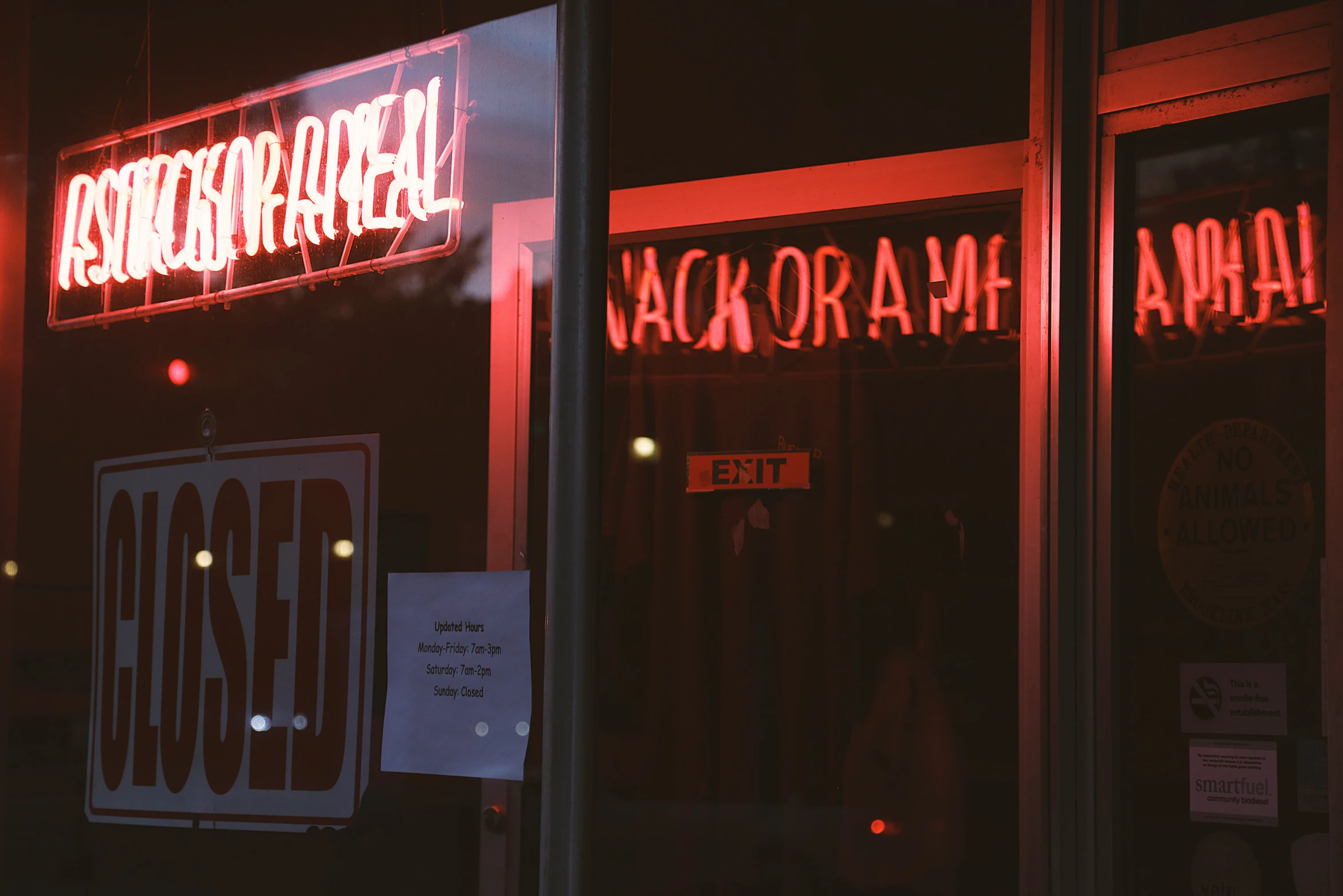 a storefront with a red light sign over it