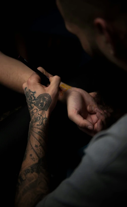 a man with a small tattoo on his arm writing