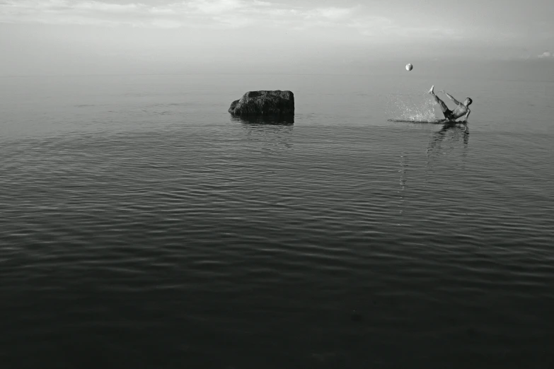 a man jumping into the water in a small boat