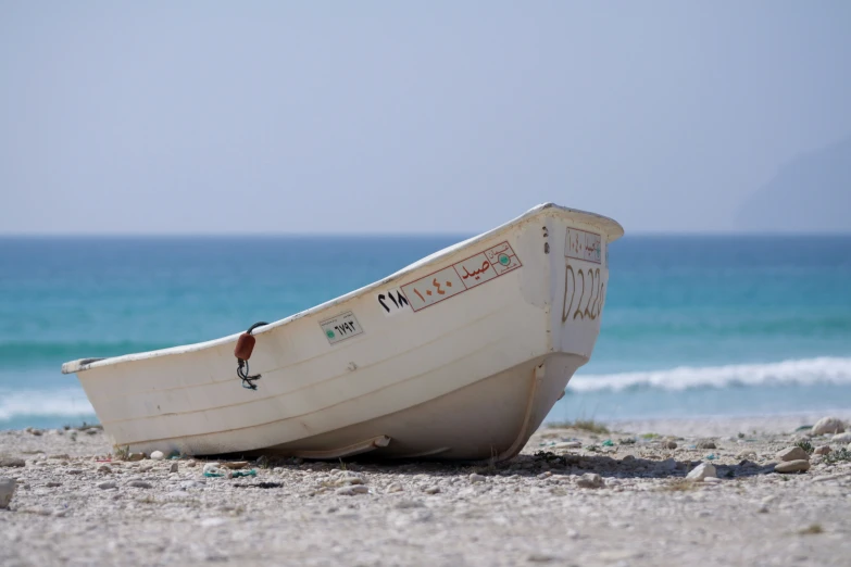 a small boat sitting on top of a sandy beach