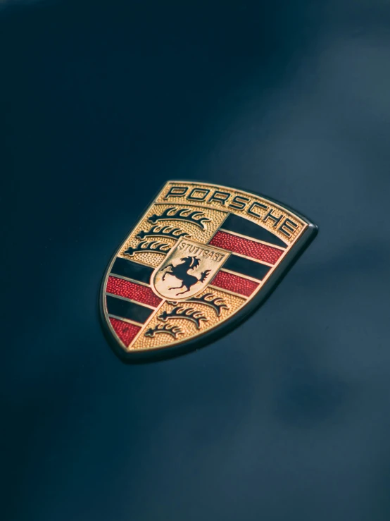the emblem on a car is painted red and gold