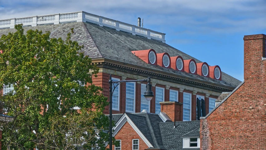 there is a large building with windows on the roof and some trees on the other side