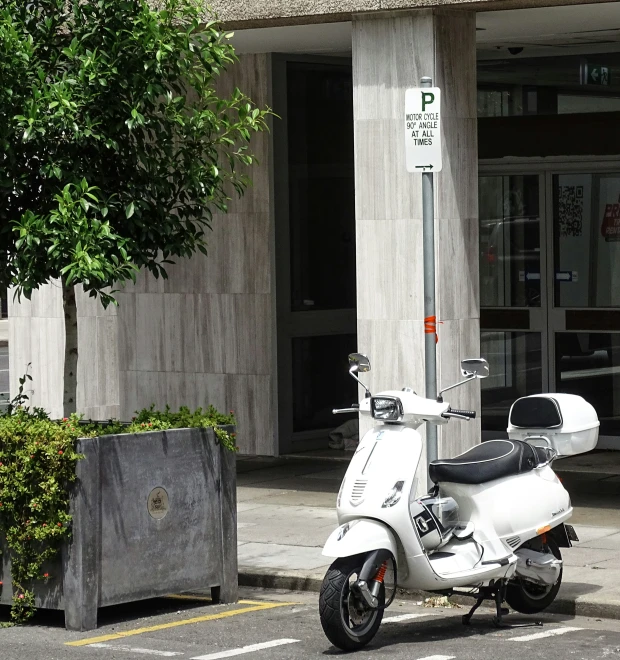 a moped parked in front of a parking meter