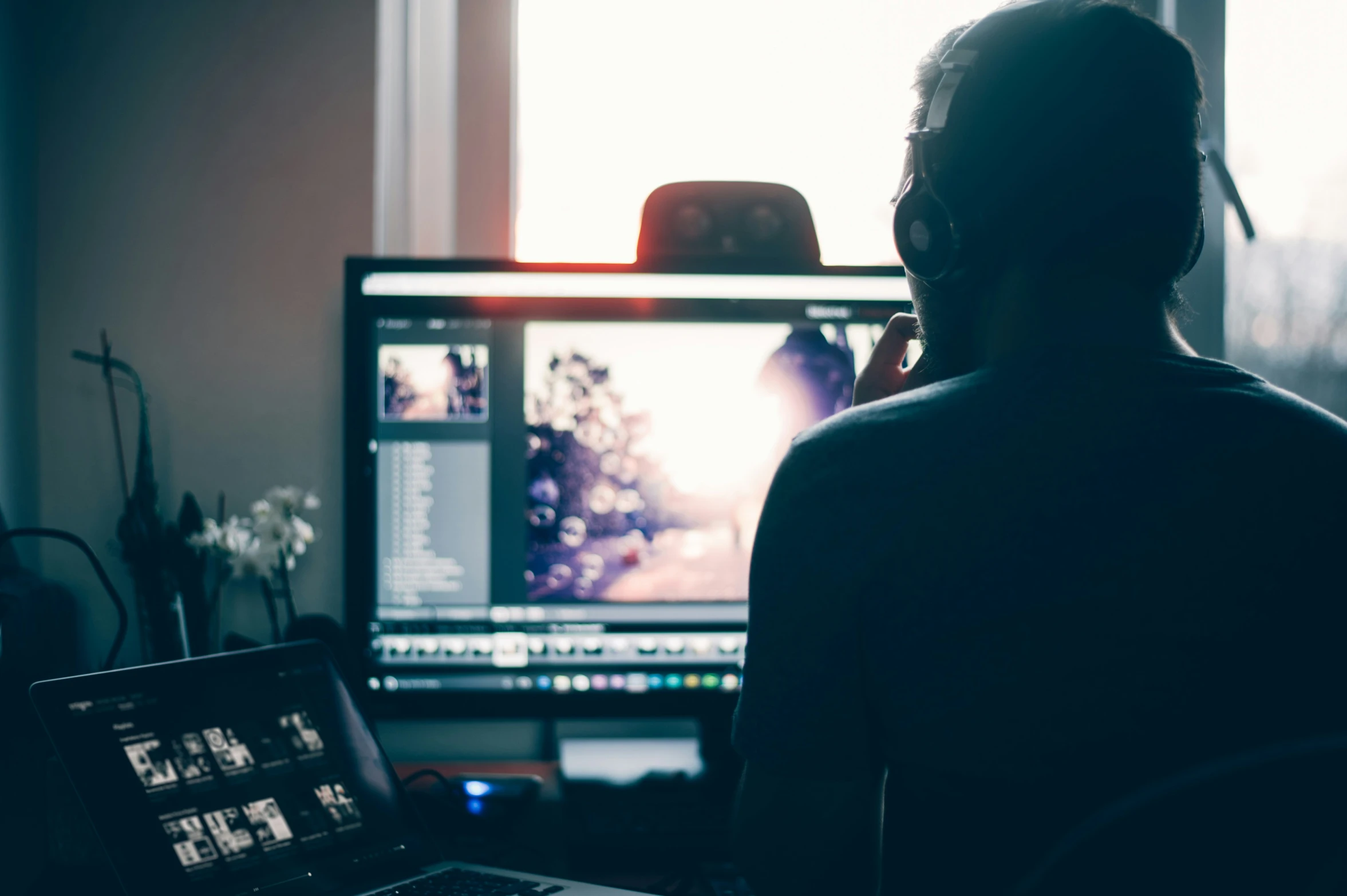 person with headphones on sitting in front of computer