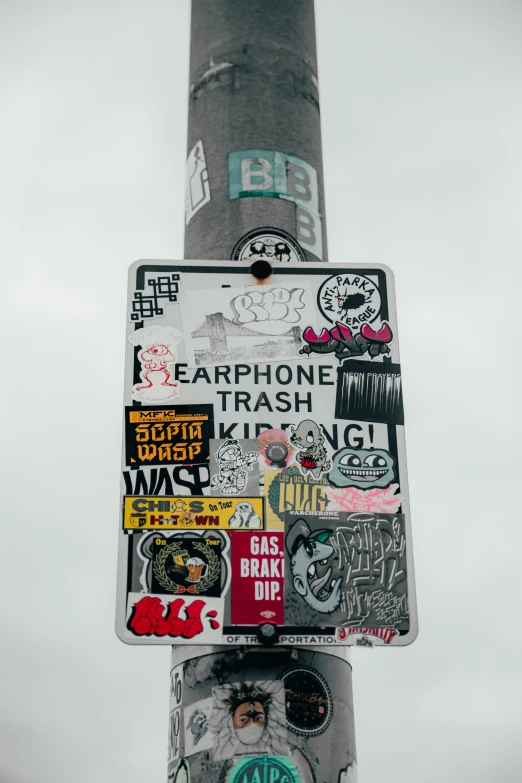 a street sign with stickers on the back of it