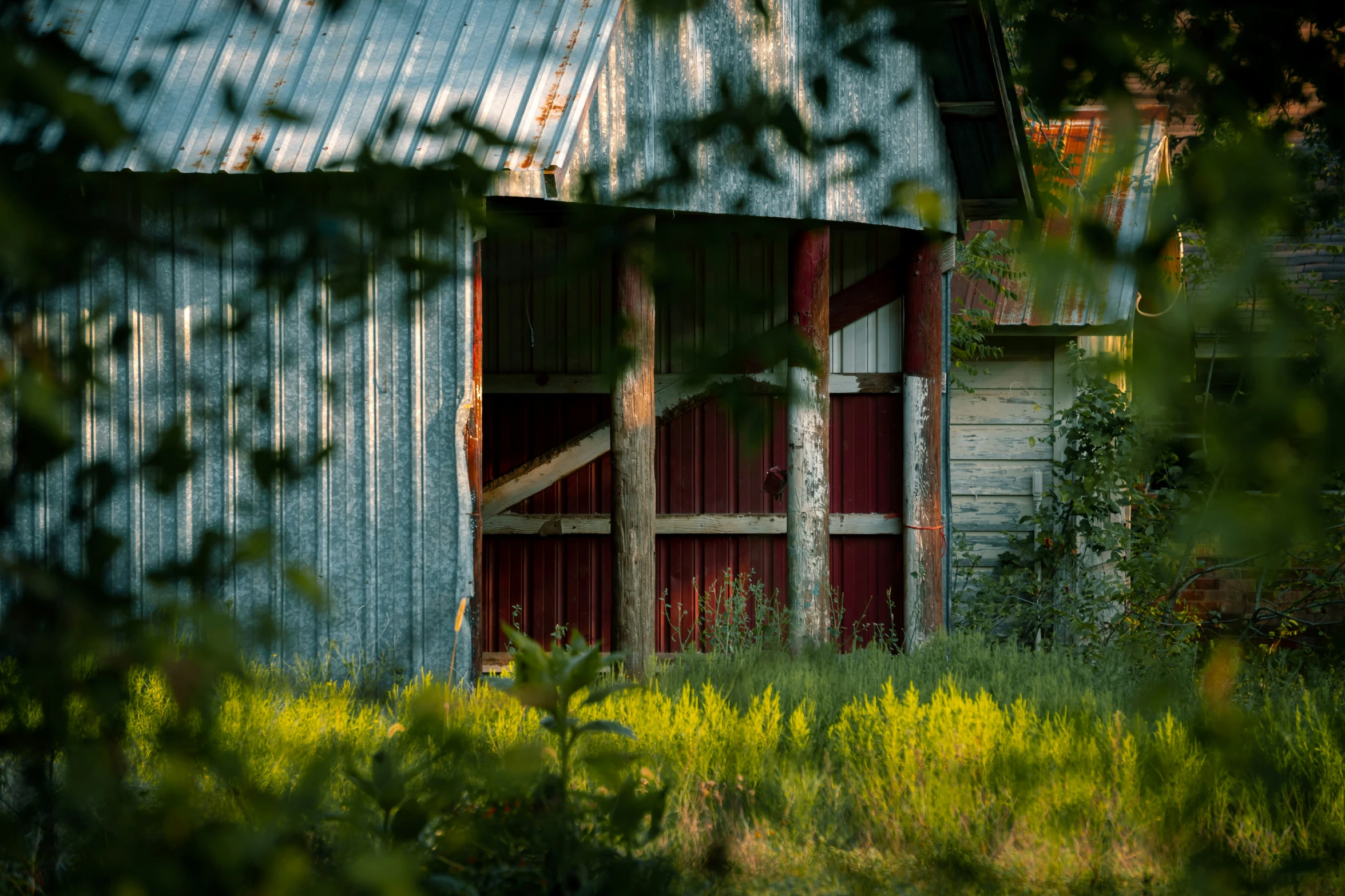 a barn with a roof and door partially open