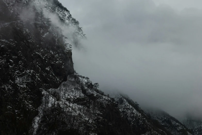 two mountains covered in snow and cloudy skies