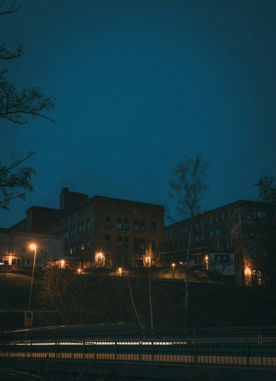 a group of apartment buildings by night with lights on