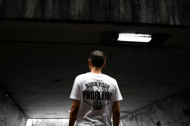 a young man is standing inside a tunnel in the concrete