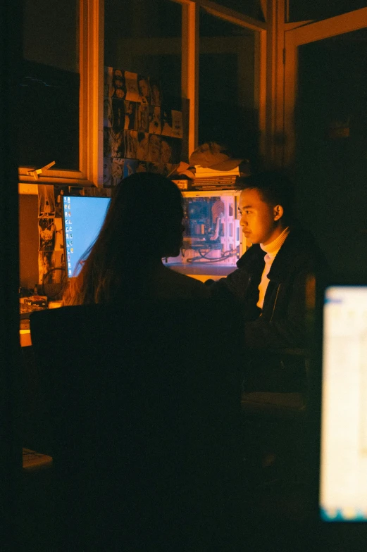 the couple is sitting down to talk at the computer desk