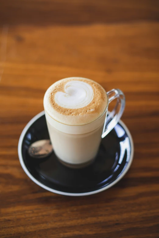 latte on a black saucer with white and gold decoration