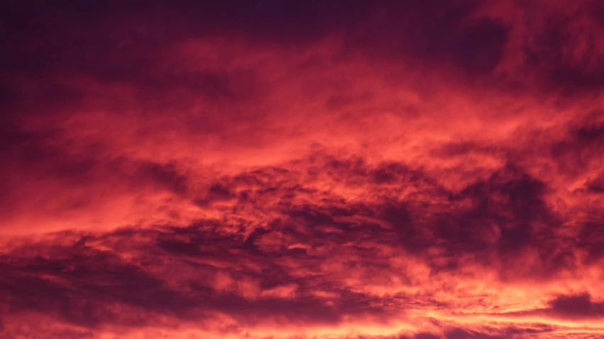 a beautiful sunset with red clouds and black planes in the sky