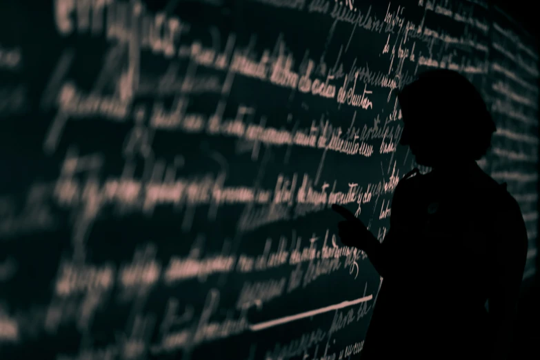 person standing next to text on black board