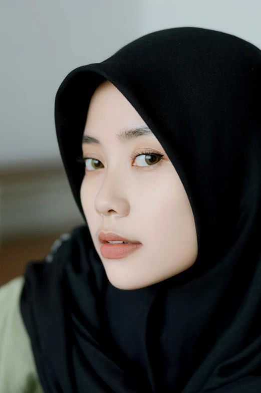 a young woman in a black headscarf with white eyes