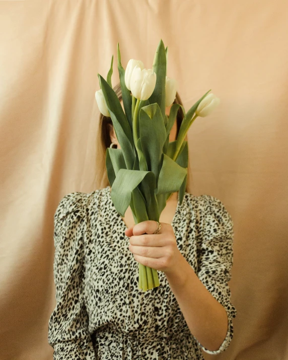 a woman holding a flower up to her face