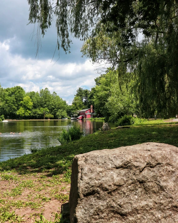 a lake and dock with large rocks in the foreground